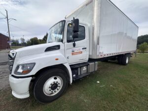 Box truck with a Men In Trucks door sign showing the Ottawa phone number.